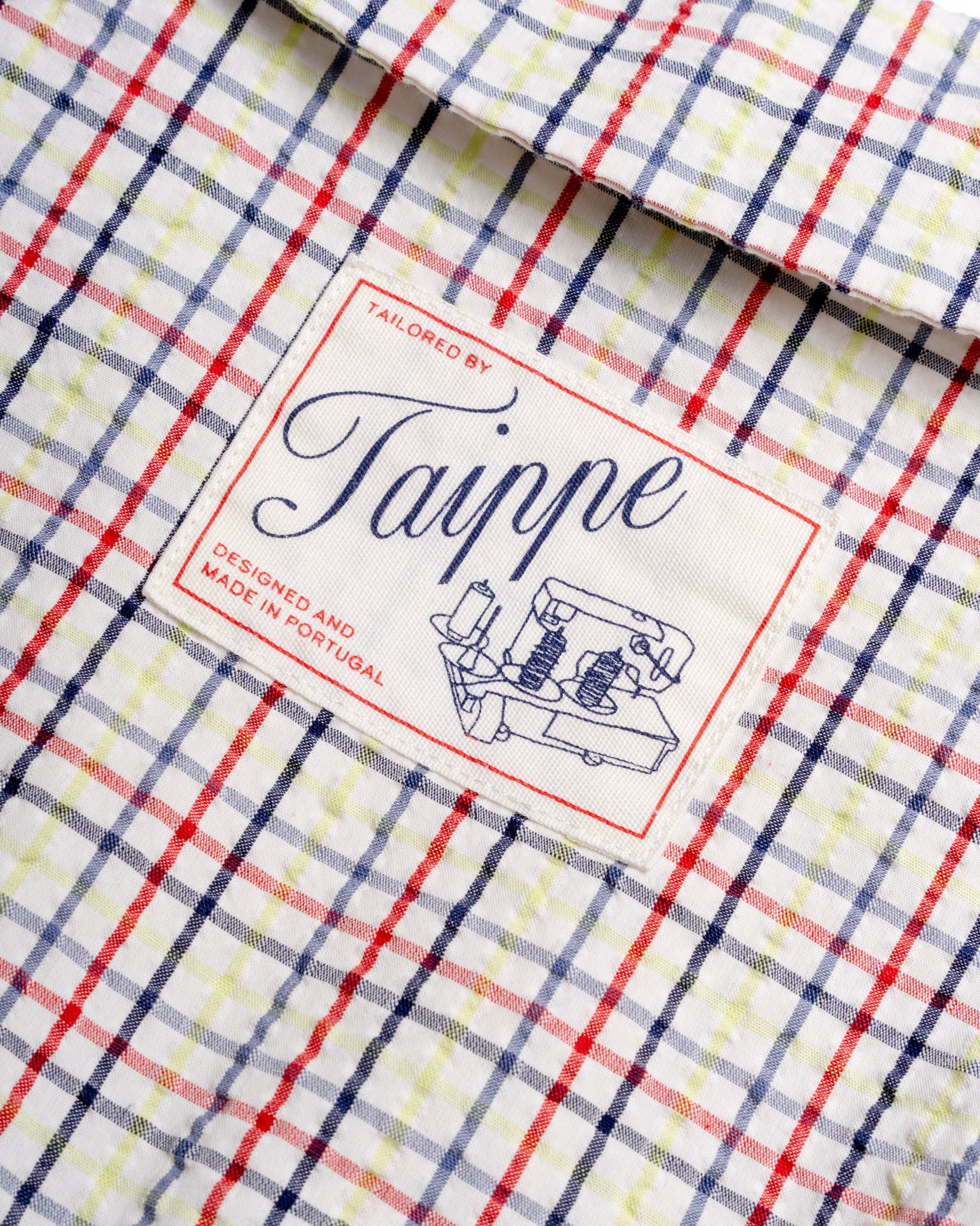 Close-up of a checkered blouse with a 'Taippe' label 