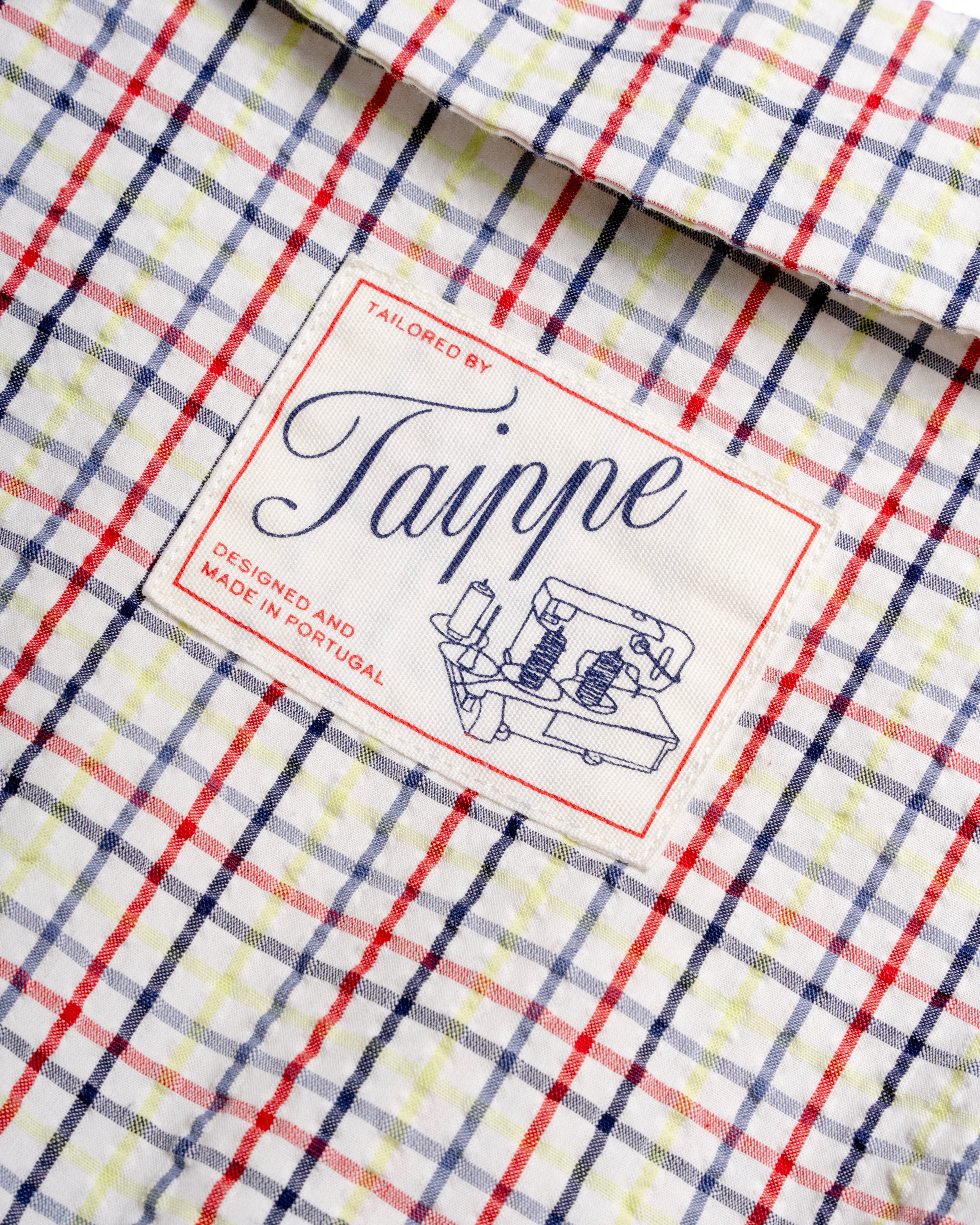 Close-up of a checkered blouse with a 'Taippe' label 
