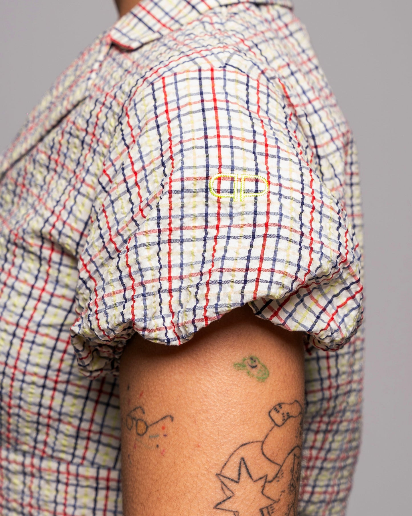 Person wearing a plaid blouse with puff sleeves