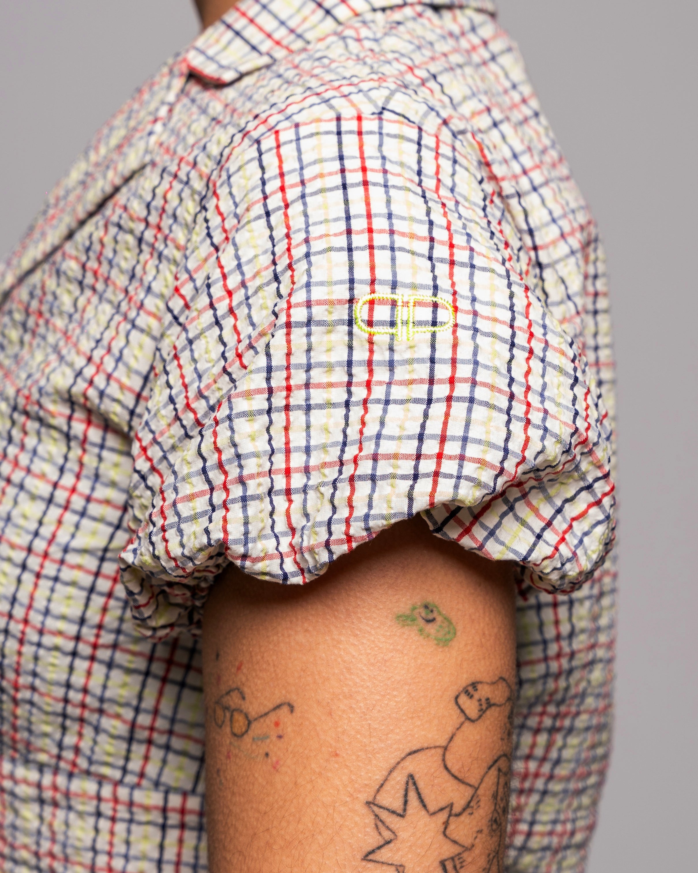 Person wearing a plaid blouse with puff sleeves