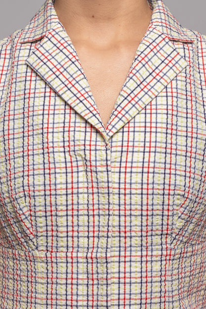 Close-up of a person wearing a plaid blouse with red and blue lines 