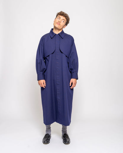 Person wearing a long blue coat on a white background